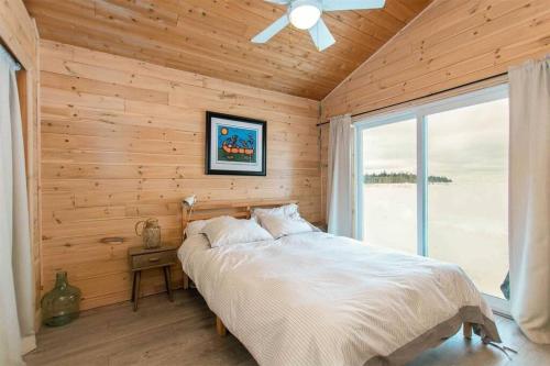 Miller Lake**WATERFRONT**BEAUTIFUL MODERN TOBERMORY COTTAGE的卧室配有木墙内的一张床
