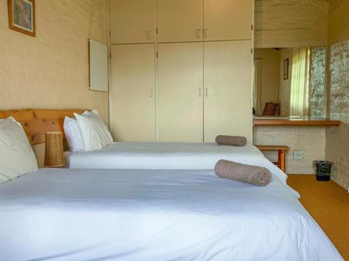 温特顿Swallowfield Estate 7 & 12 Wits End的一间卧室配有两张带白色床单和橱柜的床。