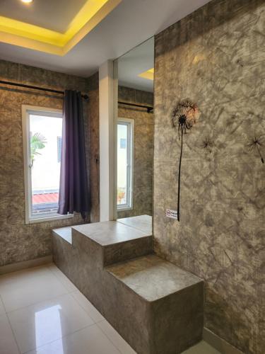 乔木提恩海滩Loft House Resort Pattaya的浴室设有石墙,墙上挂着花卉