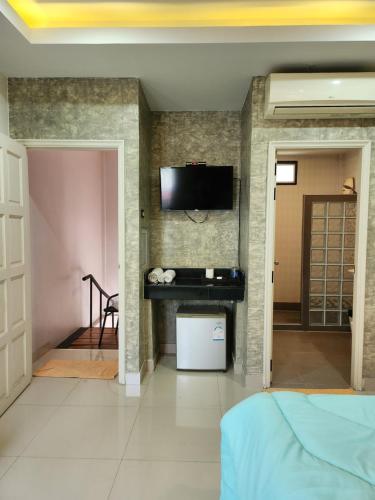 乔木提恩海滩Loft House Resort Pattaya的卧室设有壁挂式电视和床。