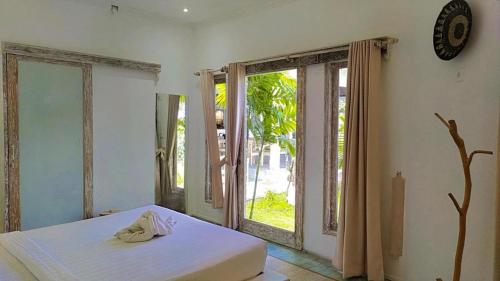 金巴兰Surga Tropical Suites的一间卧室设有一张床和一个大窗户