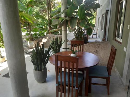 乌纳瓦图纳Hotel Paradiso,的植物间里的一张木桌和椅子
