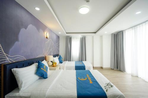 芽庄Moonlight Nha Trang Hotel的一间卧室配有两张蓝色和白色的床
