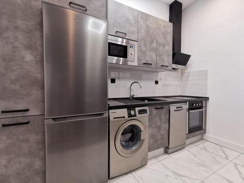 马德里Serrano Style, by Presidence Rentals的厨房配有不锈钢冰箱和洗碗机