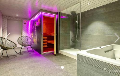 马尔梅迪Côté Mont的浴室配有浴缸和紫色灯淋浴