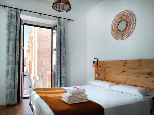 科尔多瓦La Piquera Hostal的一间卧室设有一张大床和大窗户