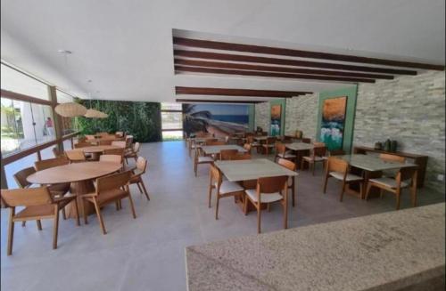 伊波茹卡Mana beach 2 quartos Muro Alto Ipojuca的一间带桌椅的餐厅以及砖墙