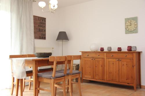 劳特尔巴赫Fewo 102 im Haus Katharina mit Terrasse的一间带桌椅和时钟的用餐室
