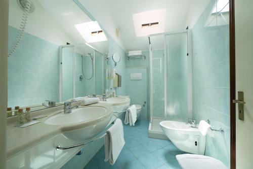 切塞纳蒂科Hotel Milano的一间带两个盥洗盆和淋浴的浴室
