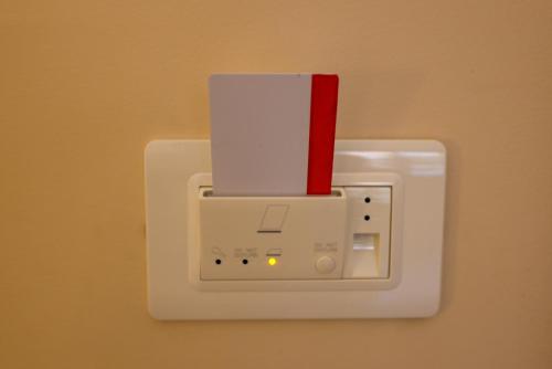 科森扎Brettia Guest Rooms的白色的灯开关,上面有红色的卡片