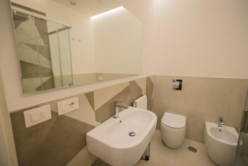 科森扎Brettia Guest Rooms的一间带水槽、卫生间和镜子的浴室