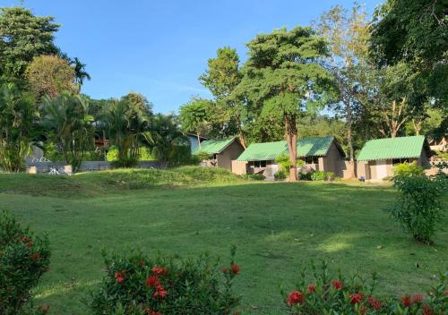 高兰Siam Flora Resort Koh Lanta的院子中一排带绿色屋顶的房屋