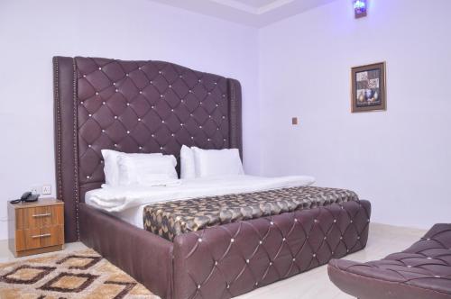 Oba IleAkure Airport Hotel的一张带软垫床头板的床