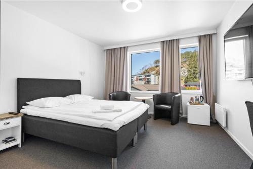 弗洛罗Kinn Hotell Florø的酒店客房带一张床、一张桌子和椅子