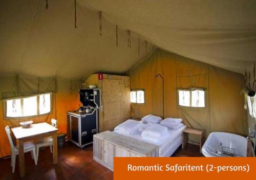霍尔滕Safaritents & Glamping by Outdoors的一间卧室配有一张床,帐篷内设有一个炉灶
