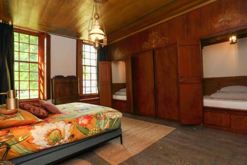 NieuwoldaHoogheem Erfgoed & Logies的卧室配有一张床铺,位于带木墙的房间内