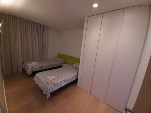 赫罗纳Camiral Golf and Wellness Luxury Villa的小房间设有两张床和一面墙