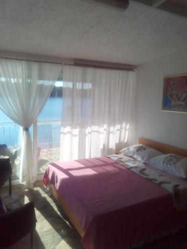 布拉托Apartment Ljilja的一间卧室设有一张床和一个大窗户