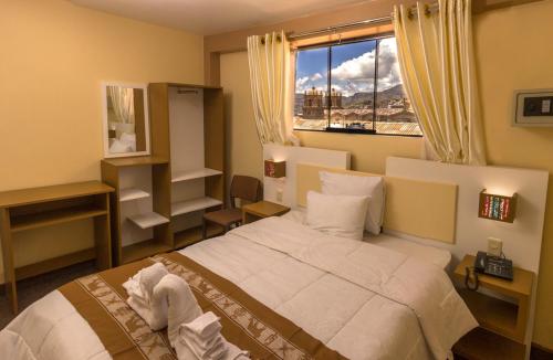 普诺Kaaro Hotel Puno的一间卧室设有一张大床和一个窗户。