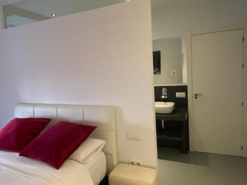 马德里Apartamento en Madrid Rio con Parking Gratuito的一间卧室配有一张带红色枕头和水槽的床