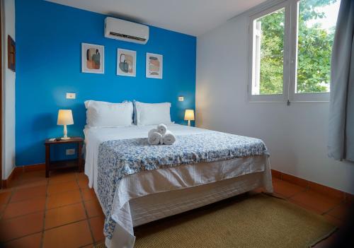 瓜鲁雅Pousada Cocal da Praia的一间蓝色的卧室,床上有两只填充动物