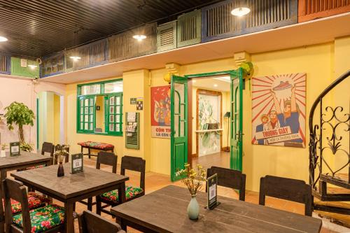 河内Hanoi Retro 80S Homestay的餐厅设有木桌和椅子以及绿门