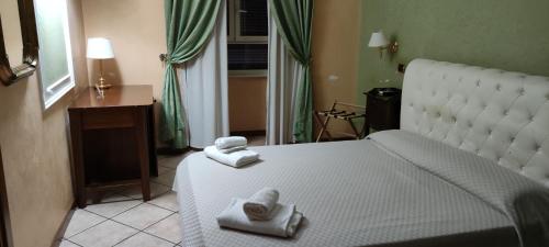 罗马Hotel Montreal Uno的卧室配有白色床和毛巾