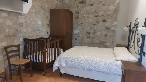 圣乔瓦尼·罗通多Tenuta Chianchito的一间卧室配有一张床、一张婴儿床和一把椅子