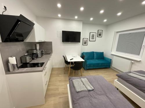 莱因费尔登-埃希特尔丁根Deluxe Apartments Messe Flughafen的小厨房以及带蓝色沙发的客厅。