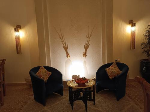 马拉喀什Riad Beni Sidel的火炉间里两把椅子和一张桌子