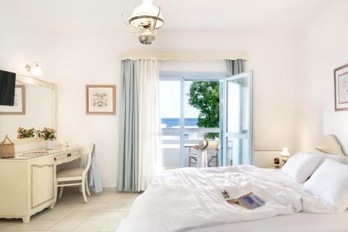斯基罗斯岛佩里吉利酒店的白色的卧室设有床、书桌和窗户