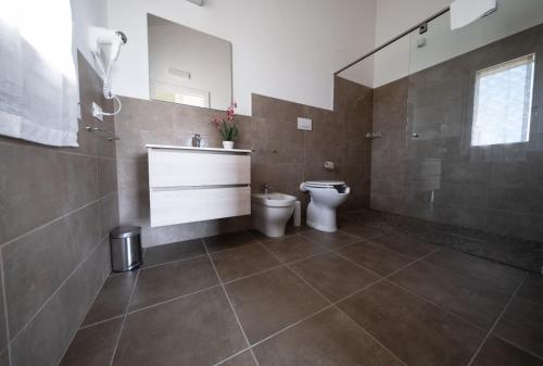 马内尔巴Villa Athena Charme的一间带卫生间、水槽和镜子的浴室