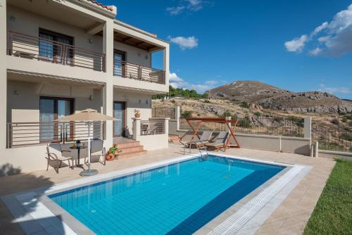 Agios Ioannis Kaspaka港口广场酒店的一座带游泳池和房子的别墅
