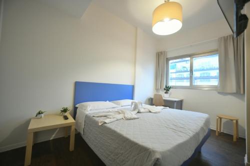 佛罗伦萨Garden Blue的一间卧室配有一张白色的床和蓝色床头板