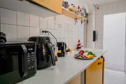 圣地亚哥Mondrian Santiago的厨房柜台配有微波炉和一盘食物