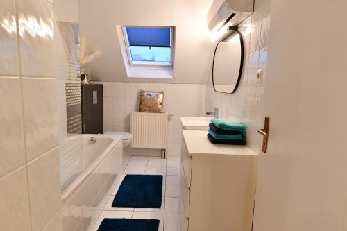 WadgassenHeimat Floral Ferienhaus的白色的浴室设有浴缸、水槽和镜子