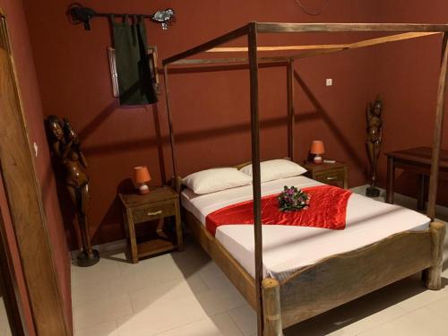 FimelaChez Kangou Lodge的一间卧室配有一张带木制床架的床