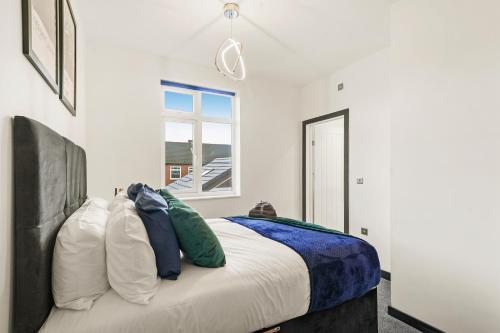 卡斯尔福德Stylish Yorkshire Gem - Sleeps 4 - Great Location的卧室配有带枕头的床铺和窗户。