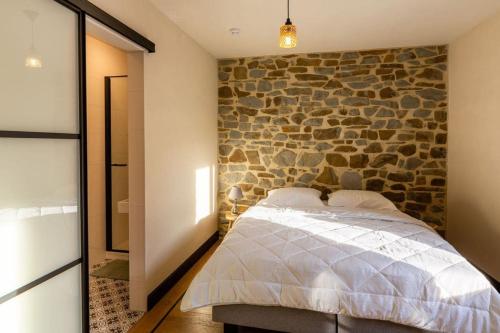 杜柏Villa Basse Cour的一间卧室设有石墙和一张床