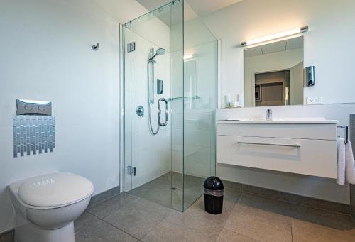 新普利茅斯普基库拉汽车旅馆的浴室配有卫生间、盥洗盆和淋浴。