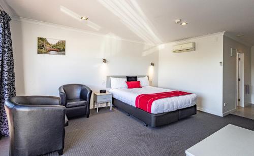 新普利茅斯普基库拉汽车旅馆的配有一张床和一把椅子的酒店客房