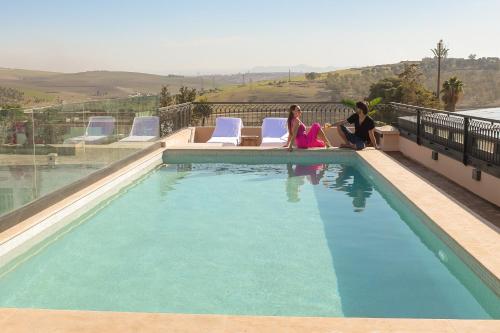 非斯DAR LYS的两个女人坐在游泳池旁边