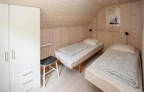Nordby2 Bedroom Pet Friendly Home In Sams的一间卧室配有两张床和椅子