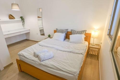 OvnatCharming unit in Dead Sea的卧室配有一张带白色床单和枕头的大床。