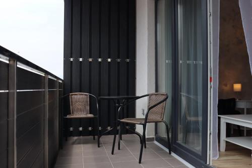 布拉索夫Apartament Onix的阳台配有2把椅子和桌子