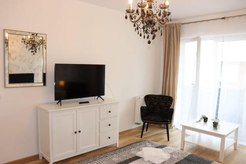 布拉索夫Apartament Onix的一间客厅,客厅的白色橱柜上配有电视