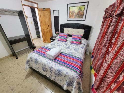 奥兰太坦波Hostal EL VIAJERO en Ollantaytambo的一间卧室配有一张带毯子和枕头的床。