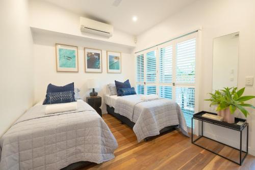 拜伦湾Swell Byron Bay - Opposite the Belongil Beach的一间卧室设有两张床和窗户。