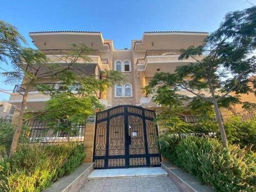 开罗New Cairo lux apt in lux villa basement1的一座树木繁茂的建筑前的大门