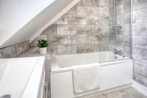 福克斯通1 or 2 bed in Folkestones West End的一间带白色浴缸的浴室,浴室设有楼梯